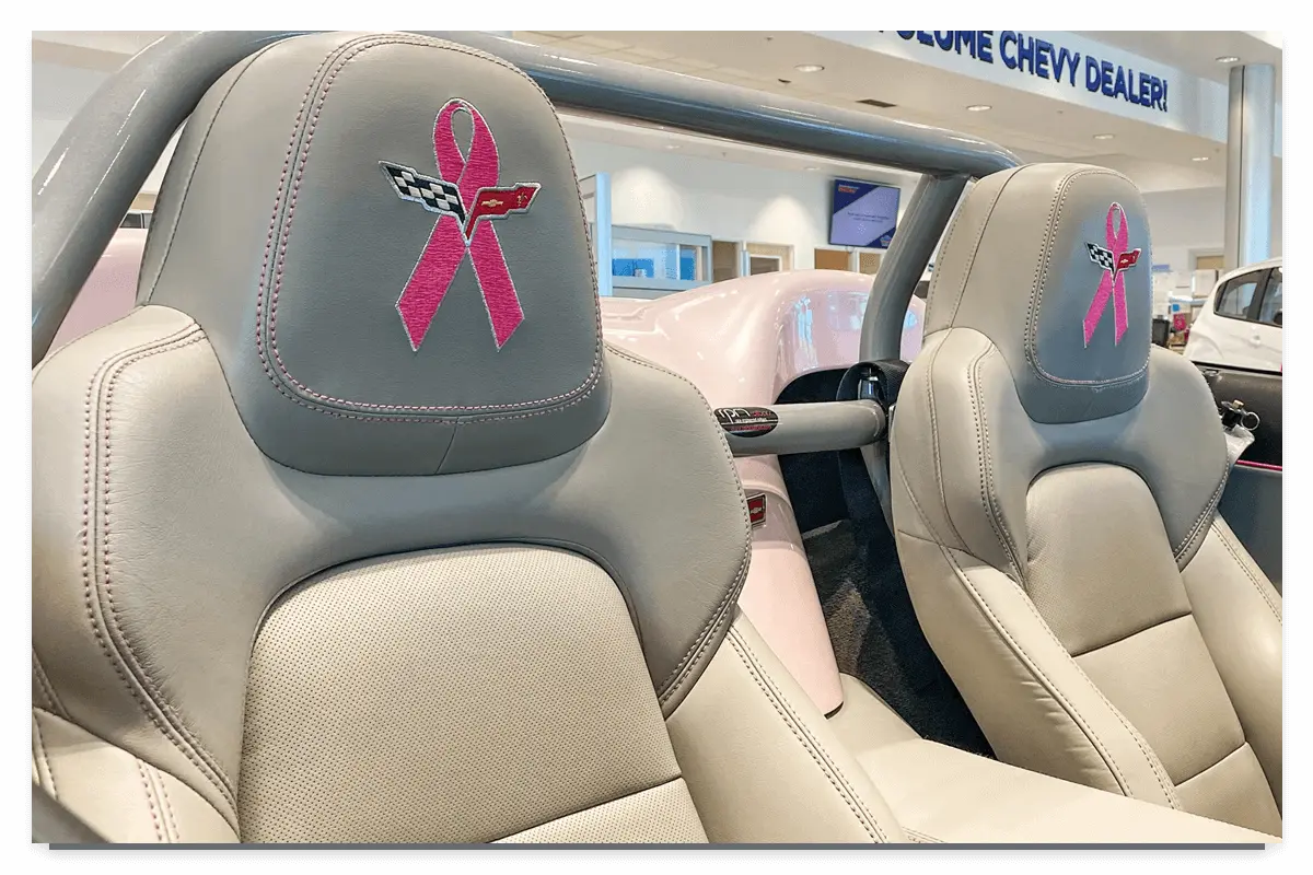The back interior view of a car with a breast cancer awareness on the headrest